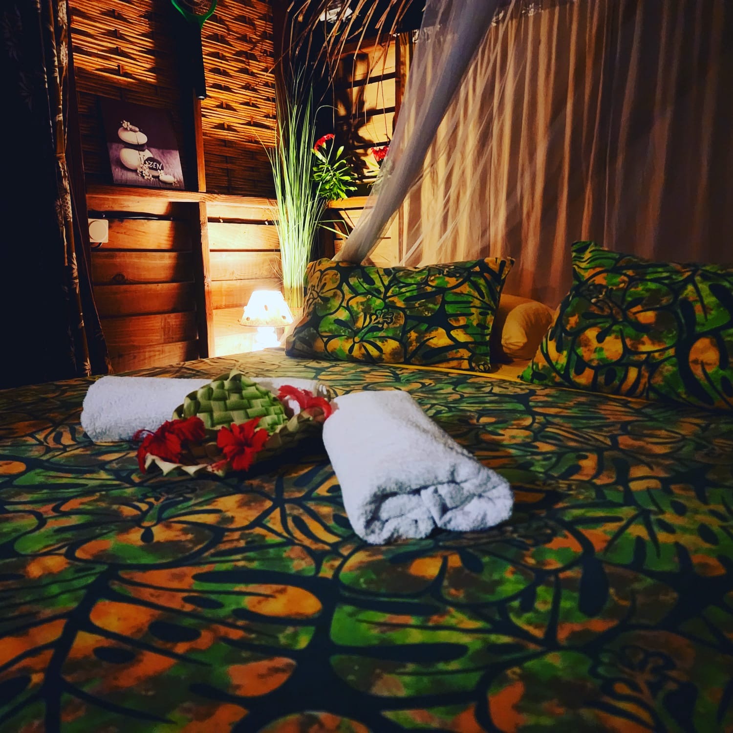 Lit du Bungalow Miti préparé avec serviettes et fleurs d'hibiscus