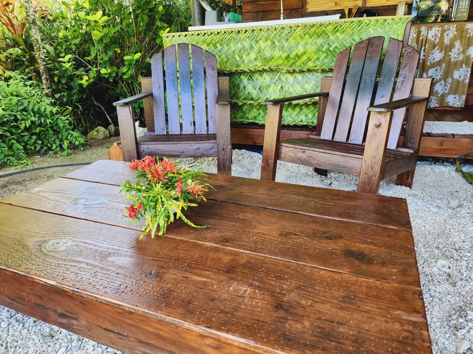 Fauteuils et table en bois devant le Bungalow Miti